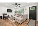 Stylish living room featuring a comfortable sectional sofa, modern ceiling fan, and sleek wood flooring at 3314 Creatwood Se Trl, Smyrna, GA 30080