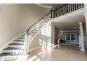 Bright foyer with curved staircase, hardwood floors, and view into the living area at 6045 Standard View Dr, Johns Creek, GA 30097