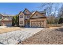 Attractive home showcasing a two-car garage, well-manicured lawn, and a welcoming entrance at 6640 Grove Crossing Ct, Cumming, GA 30028
