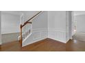 Inviting foyer featuring hardwood floors, elegant staircase, and wainscoting at 6640 Grove Crossing Ct, Cumming, GA 30028