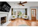 Sunlit living room showcasing hardwood floors, fireplace, with large windows and comfortable seating and decor at 1428 Downs Sw Dr, Atlanta, GA 30311