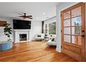 Bright living room featuring hardwood floors, fireplace, large windows, and a cozy seating area with modern decor at 1428 Downs Sw Dr, Atlanta, GA 30311