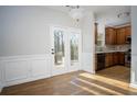 Open kitchen and dining area with hardwood floors and deck access through glass paneled doors at 2715 Maple Park Pl # 30, Cumming, GA 30041