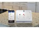 Smart home security system panel on a granite countertop, highlighting modern technology at 1828 Lacebark Elm Way, Lawrenceville, GA 30045