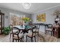 Elegant dining room features a chandelier, a large window and a round glass-topped table with seating at 2590 Runic Way, Johns Creek, GA 30022