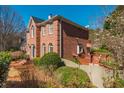 Side view of a beautiful two-story brick home with a wooden deck and lush greenery at 1231 Wildcliff Cir, Atlanta, GA 30329