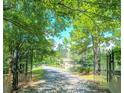 Welcoming gated entrance to a secluded property with a long driveway and beautiful lake views at 127 Hamby Ln, Social Circle, GA 30025