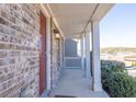 Covered front porch detail with brick facade and stately columns offer a warm, inviting entrance to the home at 1530 Avalon Creek Rd, Sugar Hill, GA 30518