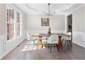 Bright dining room with hardwood floors, large windows, and a modern chandelier at 3637 Green Pine Way, Suwanee, GA 30024