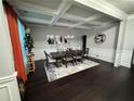 Formal dining room with coffered ceilings, chandelier, wainscoting and seating for six at 5215 Tye Trl, Fairburn, GA 30213