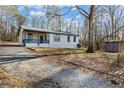 Single-story home featuring gravel drive, covered porch, and ample yard space at 3192 Highway 411 Ne, White, GA 30184