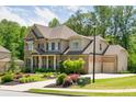Charming two-story home with a brick facade, three-car garage, and professionally landscaped front yard at 4590 Gablestone Xing, Hoschton, GA 30548