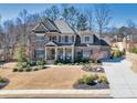 Stunning two-story brick home featuring a well-maintained lawn, lush landscaping, and a charming front entrance at 4590 Gablestone Xing, Hoschton, GA 30548