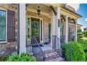 Close-up of the inviting front porch, featuring brick steps, a wooden door, and decorative columns at 4590 Gablestone Xing, Hoschton, GA 30548
