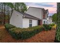 Townhome's side view showcases the siding, roofline, and trimmed hedges at 2958 Stonecrest Ln, Lithonia, GA 30038