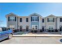 Street view of townhomes featuring varied colors, well-kept landscaping, and a blue BMW parked out front at 402 Whippet St, Union City, GA 30291