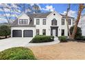 Charming two-story home with a white brick exterior, manicured landscaping, and a two-car garage at 6268 Braidwood Nw Run, Acworth, GA 30101