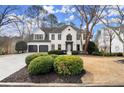 Charming two-story home with a white brick exterior, manicured landscaping, and a two-car garage at 6268 Braidwood Nw Run, Acworth, GA 30101