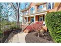 A stunning brick home featuring a columned porch, black shutters, and professionally landscaped yard at 650 Vinings Estates Se Dr, Mableton, GA 30126
