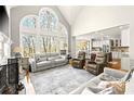 Bright living room with tall arched windows, fireplace, and open floor plan to the kitchen at 650 Vinings Estates Se Dr, Mableton, GA 30126