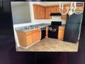 Functional kitchen with wood cabinets, granite countertops, and black appliances at 312 Lauren Dr, Fairburn, GA 30213