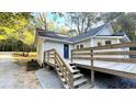 Back exterior of home showing a wooden deck, stairs, and a blue door at 8083 Highway 166, Douglasville, GA 30135