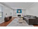 Cozy living room featuring a fireplace, built-in bookshelves, and a comfortable gray sectional sofa at 1835 Tree Top Way, Marietta, GA 30062
