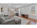 Bright living room with hardwood floors, a gray sectional sofa, and a staircase leading to the second floor at 1835 Tree Top Way, Marietta, GA 30062