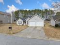 Traditional home with a two-car garage and a long driveway. The yard needs some TLC at 4768 Score Ct, Snellville, GA 30039