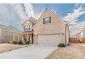 Attractive two-story brick home with a two-car garage, covered porch, and well-manicured lawn at 879 Tranquil Way, Hampton, GA 30228