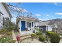 Charming home featuring a cozy front porch with a blue door and well-manicured landscaping at 818 Virgil Ne St, Atlanta, GA 30307