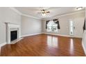 Spacious living room features hardwood floors, fireplace and a large window at 4550 Cold Spring Ct, Cumming, GA 30041