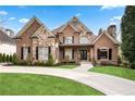 Beautiful brick and stone home with manicured lawn and inviting curb appeal at 8760 Colonial Pl, Duluth, GA 30097