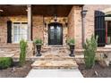 Inviting front entry with stone steps, ornate iron door, and well-manicured landscaping at 8760 Colonial Pl, Duluth, GA 30097