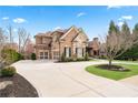 Spacious brick home with an expansive driveway and a well-manicured lawn at 8760 Colonial Pl, Duluth, GA 30097