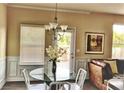 Cozy dining area showcasing natural light, modern chandelier, and a glimpse into the living space at 326 Lauren Dr, Fairburn, GA 30213