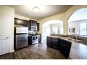 Modern kitchen with stainless steel appliances, dark wood cabinets, and an open view of the dining area at 326 Lauren Dr, Fairburn, GA 30213