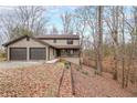 Charming two-story home featuring a two-car garage and a cozy front porch nestled on a hillside at 3865 Whitney Pl, Duluth, GA 30096