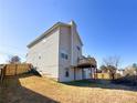 View of the backyard with a wood fence, grassy area, and a raised deck attached to the home at 5546 Wellborn Creek Dr, Lithonia, GA 30058