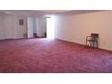 Spacious finished basement with pink carpet, a chair and multiple doors at 5546 Wellborn Creek Dr, Lithonia, GA 30058