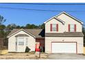 Charming two-story home features a large garage, neutral siding, red trim, a bay window, and a well-maintained yard at 5546 Wellborn Creek Dr, Lithonia, GA 30058