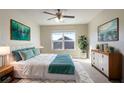 Comfortable bedroom featuring a ceiling fan, large windows, and stylish contemporary decor at 473 Broder Farms Dr, Stockbridge, GA 30281