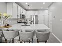 Modern kitchen with white cabinets, stainless steel appliances, and a quartz countertop island with seating at 840 Ash St, Canton, GA 30114