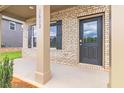 Inviting front porch with brick detail and a stylish front door at 204 Crabapple Rd, Mcdonough, GA 30253