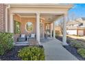 Inviting covered front porch with seating, columns, and decorative accents at 138 Lakestone Pkwy, Woodstock, GA 30188