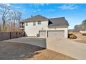 Side view of house featuring a spacious driveway leading to a three-car garage and upper level deck at 138 Lakestone Pkwy, Woodstock, GA 30188