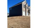 Rear side view of a two-story home featuring dark siding at 654 Egrets Lndg, Covington, GA 30014