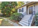 Close-up view of the front entrance featuring a black door, concrete steps, and wrought iron railing at 1031 Lindridge Ne Dr, Atlanta, GA 30324