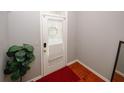 A bright entryway with a red rug, white door and gray walls at 1290 Adcox Sq, Stone Mountain, GA 30088