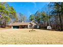 Single-story home with a well-maintained lawn and storage shed, surrounded by tall trees at 33 Bo Xing, Temple, GA 30179